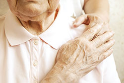 Older woman having hand held by another